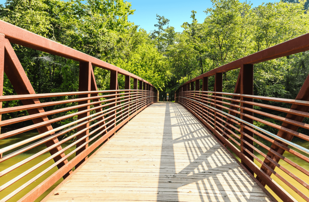 A view across a nature park bridge in Woodstock, GA, on a sunny day.