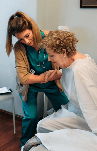 nurse helping a elder pateint get down the bed